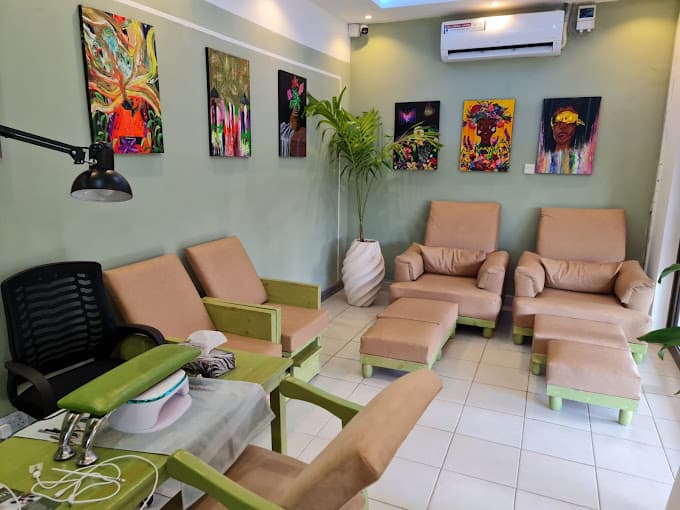 Gallery-inspired spa lounge with sage green walls and colourful artwork